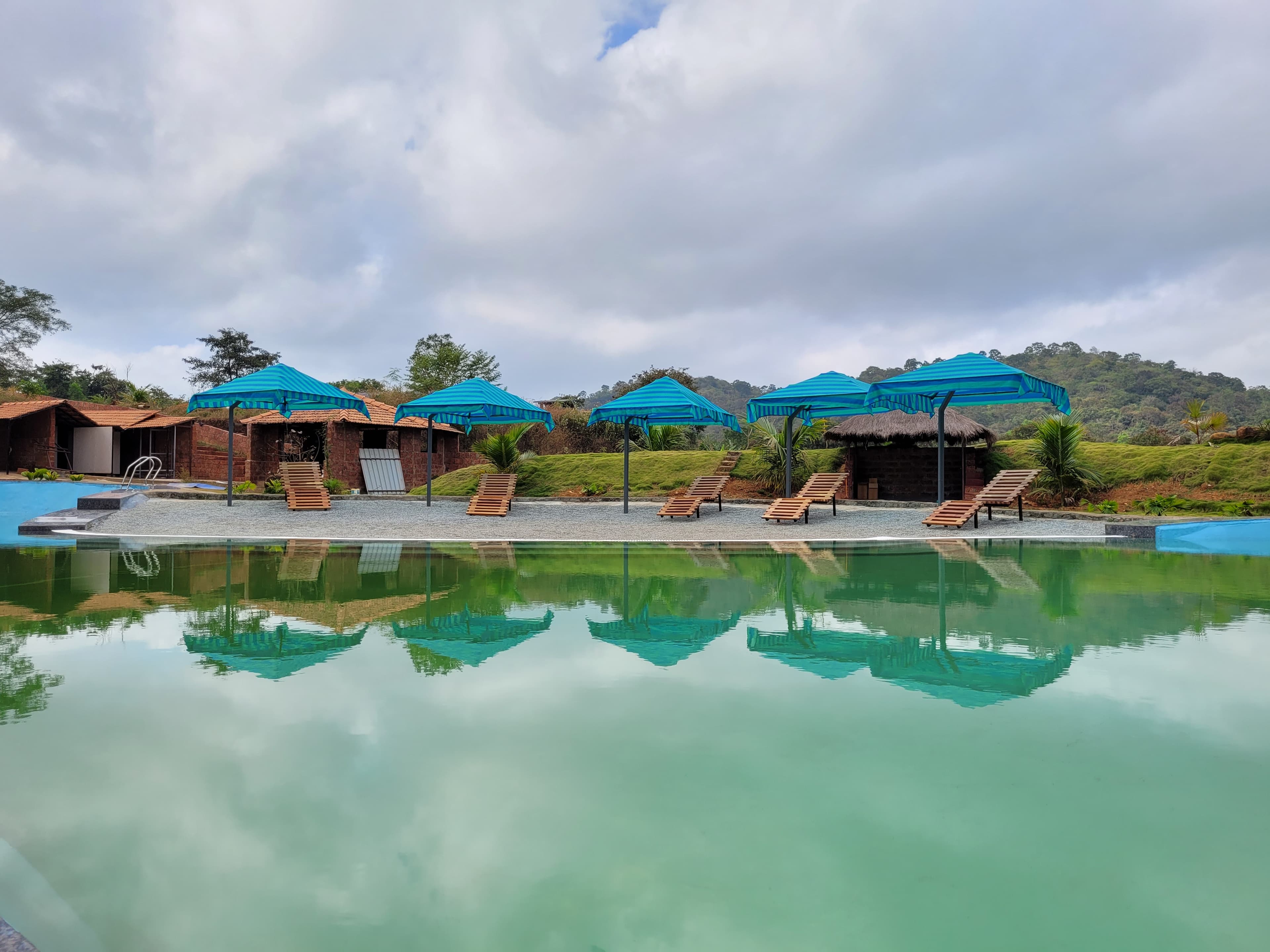 The Dandelion Resort — pool with forested mountain backdrop, Western Ghats
